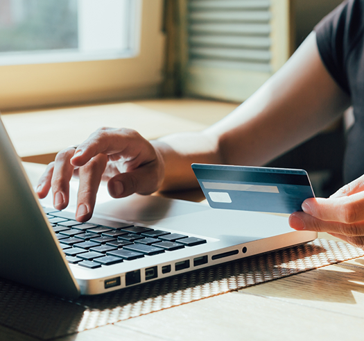 Person entering their credit card information onto a laptop