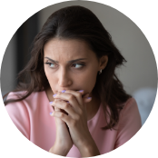 Woman looking worried with her hands folded in front of her mouth